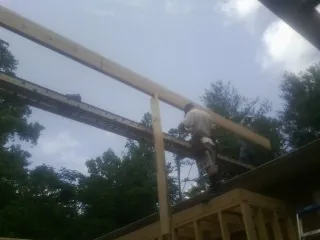 Carpenter setting a ridge beam over a new addition frame — Ice Dam Removal by Roofing Brothers in Browns Mills