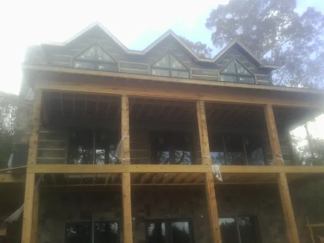 Dormers and porch framing on a large log home under construction — Roof Coating work by our crew in Browns Mills