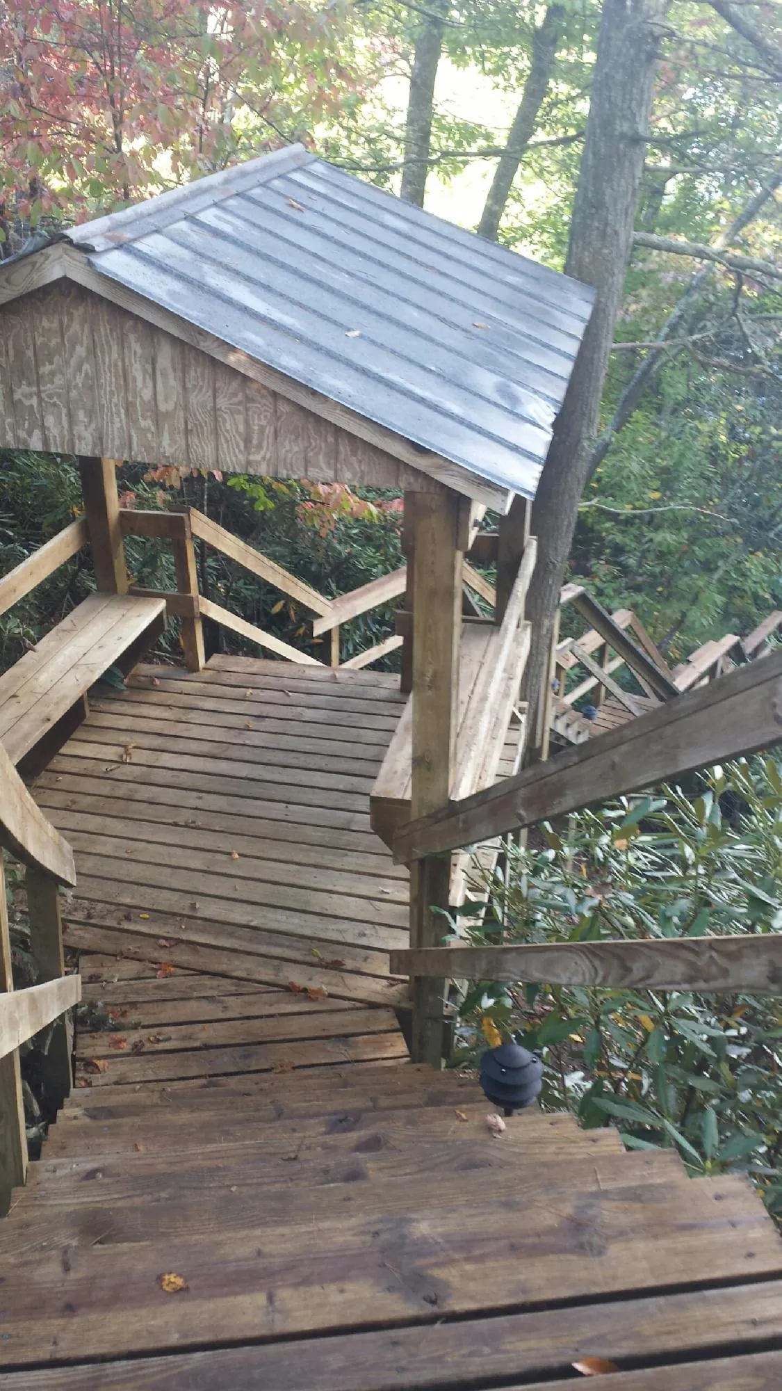 Metal roofed shelter over wooden steps on a wooded walkway — Skylight Repair & Installation work by our crew in Browns Mills